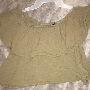 In olive green crop top that goes on the shoulders